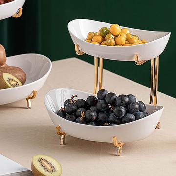 2-tier Nordic white serving stand with golden accents showcasing berries in both bowls, placed elegantly on a table.