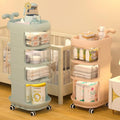 A 4-layer whale cart with open shelves and a cupboard, displayed in a nursery room setting, in shades of blue and pink.