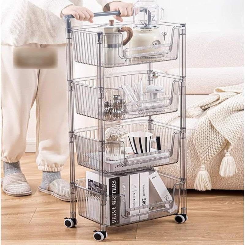 A 4-tier utility storage cart with clear shelves, being pushed by a person in a white sweatsuit. The cart is filled with various items such as a coffee maker, books, and cleaning products.
