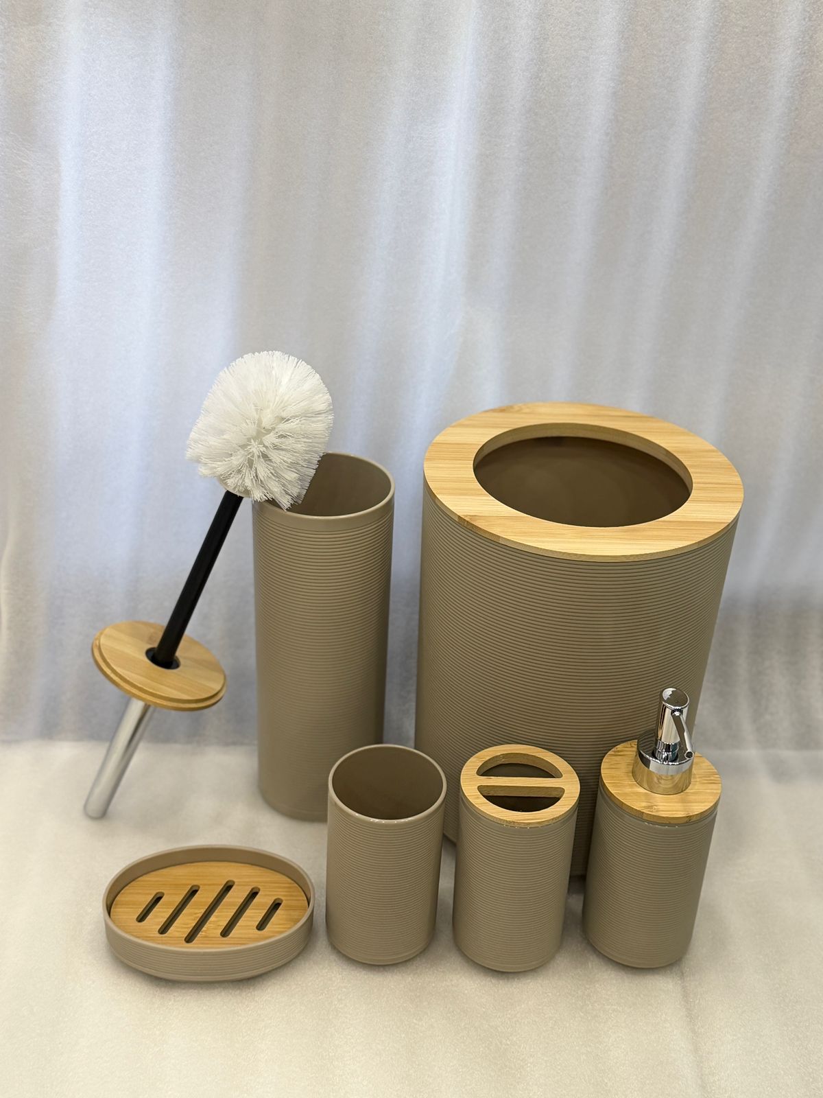 Set of bathroom accessories including a scrubber, brush holder, and various containers on a white background. Color Beige 