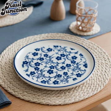 Blue and white floral-patterned plate on a woven placemat with 'Haul Junction' branding.