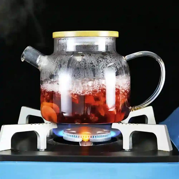 Glass kettle teapot boiling tea on a gas stove, showcasing its heat-resistant design, and suitability for direct stovetop use.