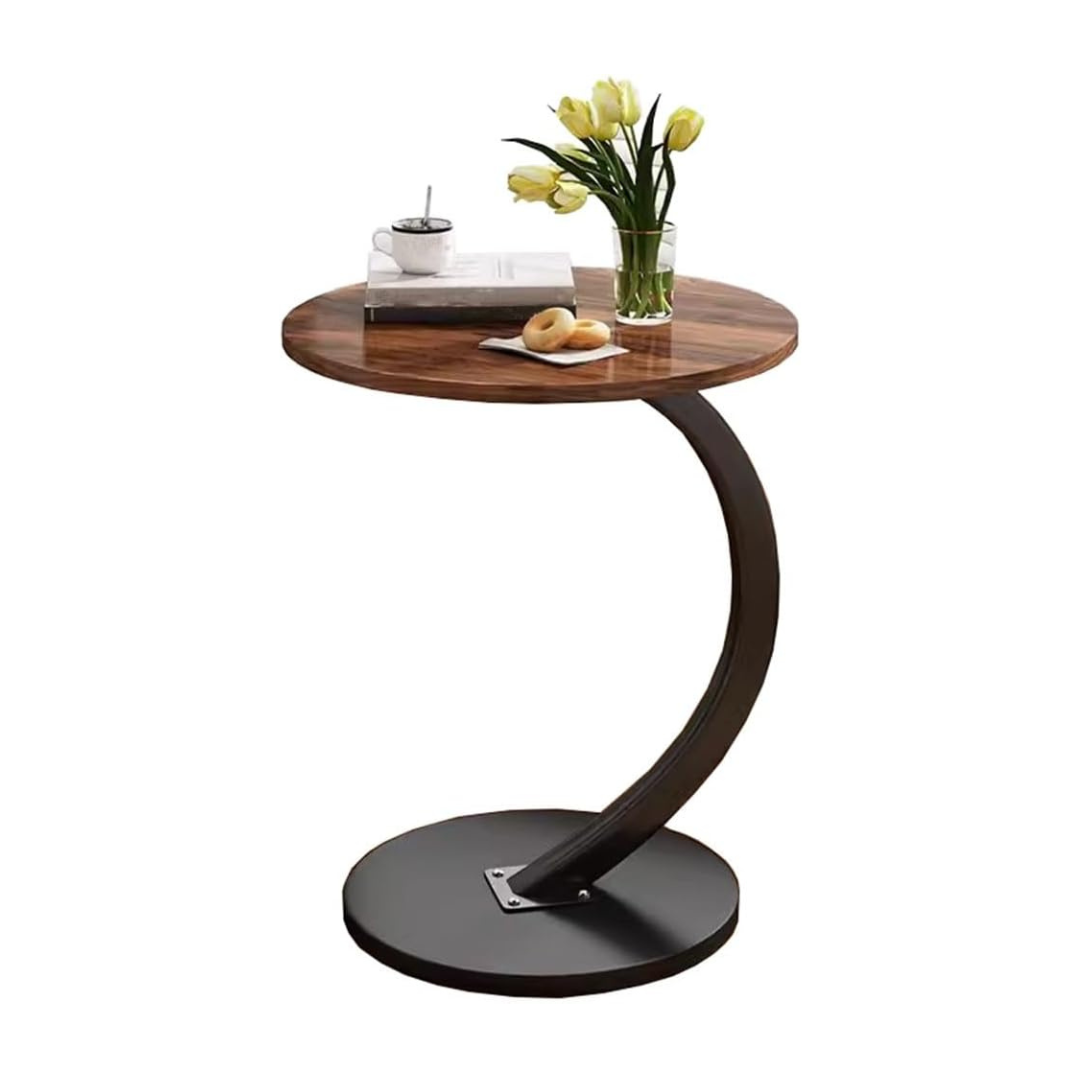 A C-shaped circular wooden side table with a metal frame, displaying a book and a vase with yellow tulips on its surface.