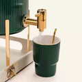  Close-up of a cup being filled with water from the dispenser, with a golden spoon beside it, emphasizing the luxurious details.