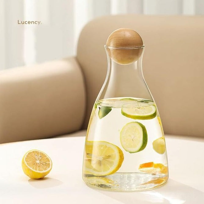 Close-up of a glass water jug placed on a tabletop, highlighting its elegant design.