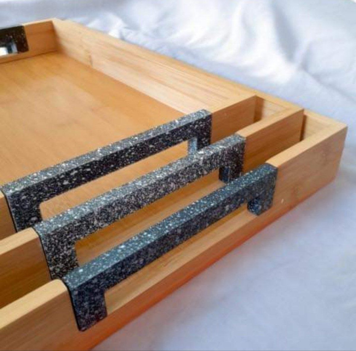 Close-up of metal handles on the bamboo serving trays