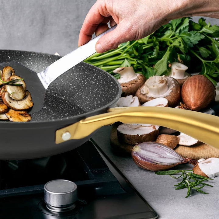 Close-up of the ergonomic gold handle of the Danny Home™ Aluminum Frying Pan. The handle stays cool for a comfortable and secure grip while cooking.