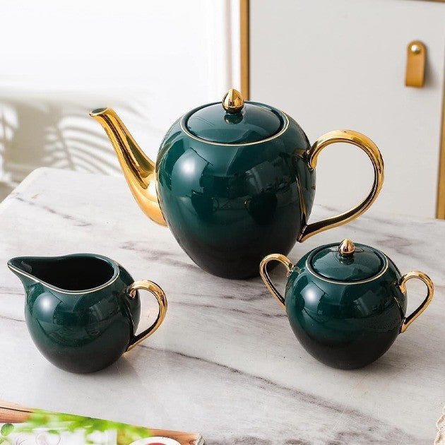 Close-up of the teapot, creamer, and sugar bowl from the tea set, highlighting their details.