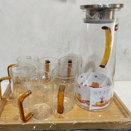 Complete Delicate Glass Jug Set featuring 6 glasses and 1 jug with a metal lid, all resting on a tray. The jug and glasses have elegant brown handles.