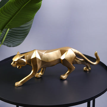 Gold leopard ornament placed on a black tabletop, showcasing its sleek and geometric design.