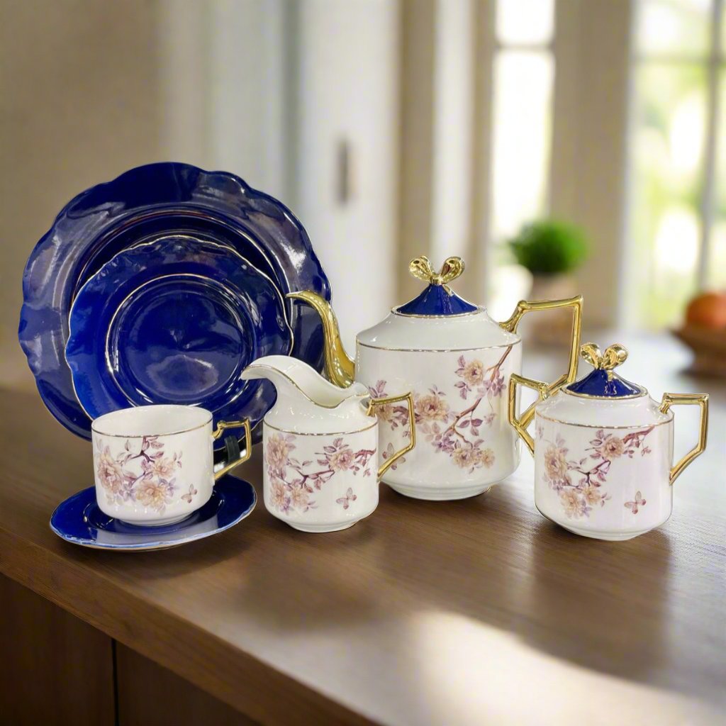 Modern ceramic floral teaset with blue plates and white mugs, featuring intricate floral design. Includes 18 pieces: teapot, sugar pot, creamer, flat plates, tea cups, and saucers.