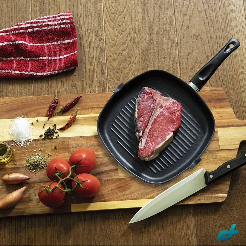 Non-stick aluminium grill pan with kebabs cooking, showcasing its non-stick surface for easy grilling."