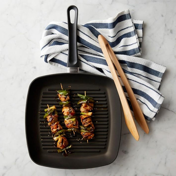 Non-stick aluminium grill pan with kebabs cooking, showcasing its non-stick surface for easy grilling."