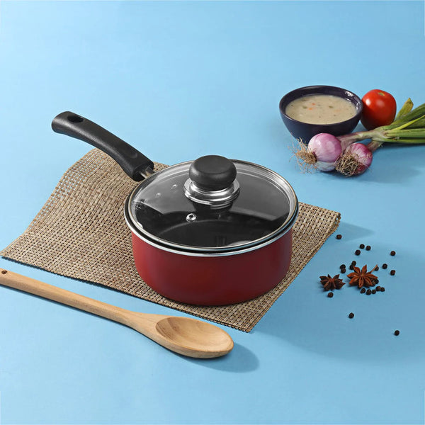 Non-stick saucepan with a closed lid, accompanied by a bowl of sauce and raw ingredients on the side, showcasing its practical design.