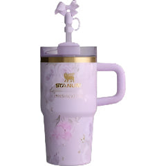 A purple STANLEY tumbler with a floral pattern and a flow state lid, featuring a straw opening.