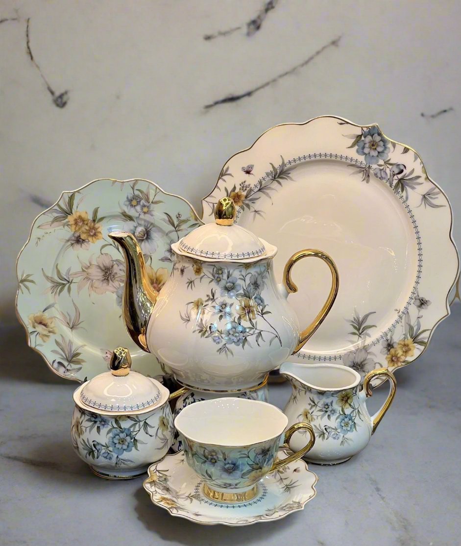 Showcasing a white fine bone china tea set with a delicate floral design, featuring teapot, cups, saucers, and accessories elegantly arranged.