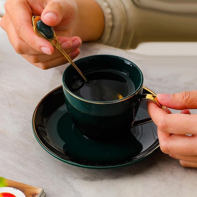 Tea cup filled with tea, placed on a matching saucer with a spoon, showcasing the elegant serving experience.