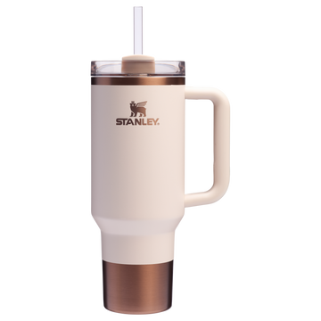 A white and gold colored tumbler with a handle and a straw spout, featuring the Stanley brand logo.