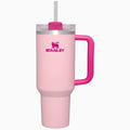 Pink Stanley tumbler with a handle on a white background
