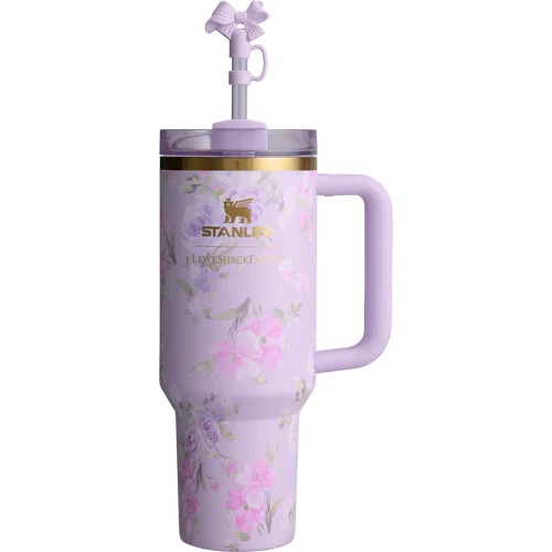 A purple Stanley Quencher tumbler with floral patterns and a straw spout.