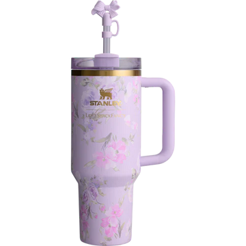 A purple Stanley Quencher tumbler with floral patterns and a straw spout.