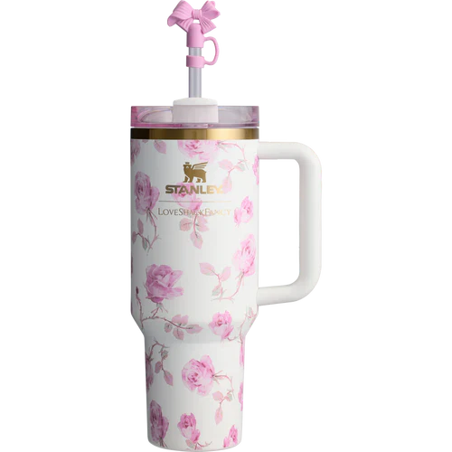 A white stainless steel Stanley Quencher tumbler with pink floral pattern and a pink lid and straw.