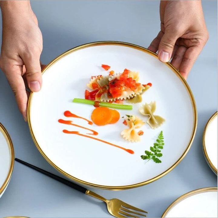 Top view close-up of a large plate with food, highlighting the luxurious gold trim and white ceramic design.