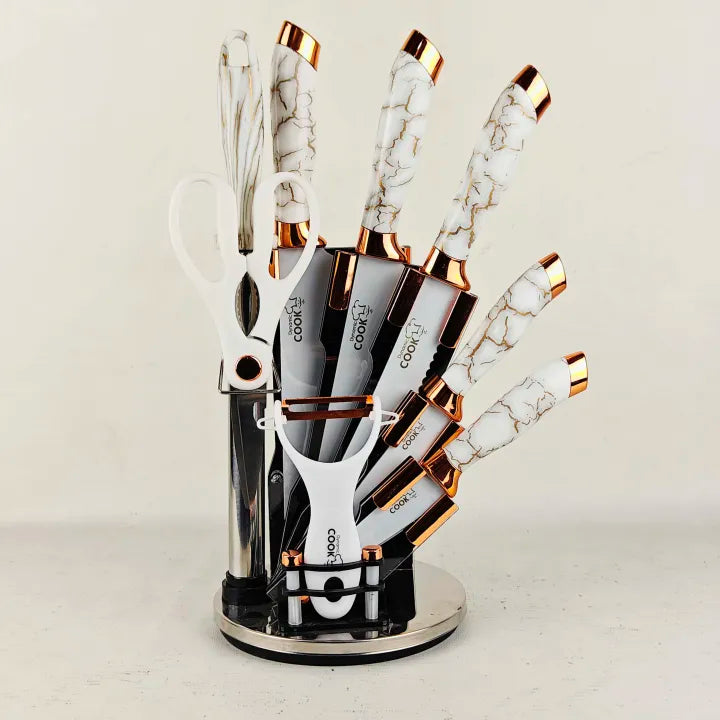 White textured handle knife set with rose gold accents, all pieces displayed in the acrylic rotating stand.