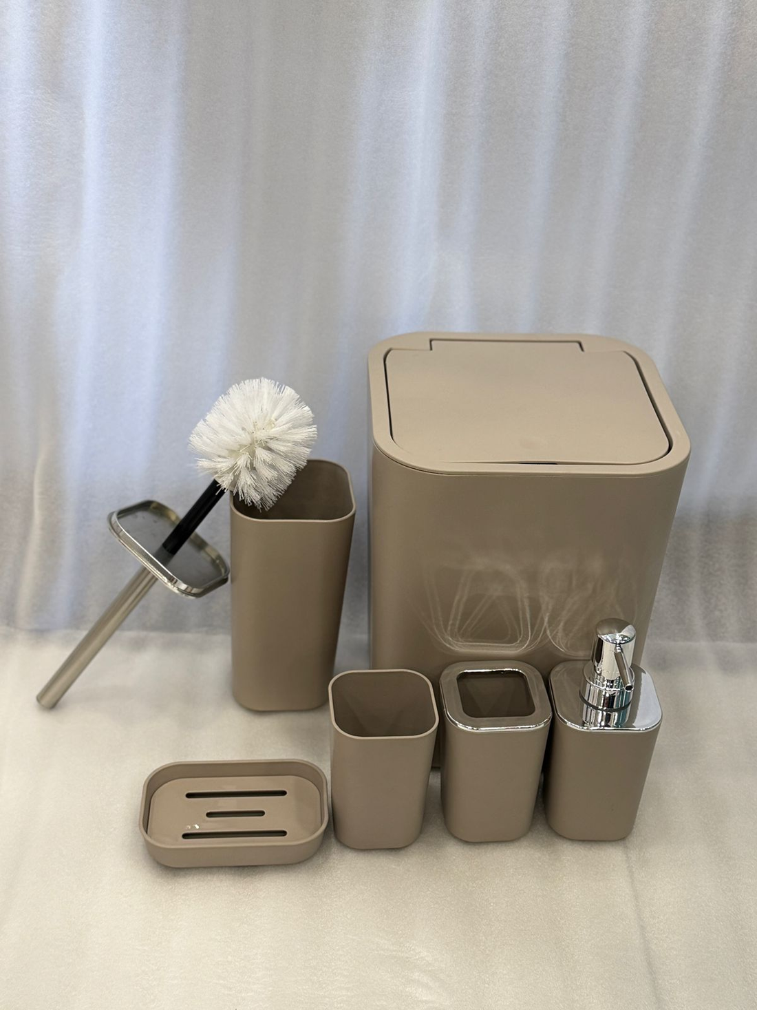 Bathroom set with beige trash bin, soap dispenser, and other accessories in a bathroom setting.