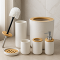 Bathroom accessories set with white containers, wooden accents, and a brush on a neutral background