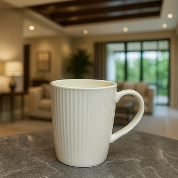 White ceramic mug on a marble surface with a blurred indoor setting in the background