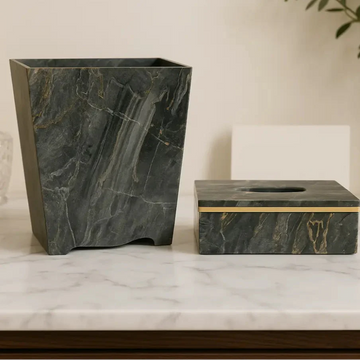 Marble-patterned trash can and tissue box on a marble surface with a neutral background