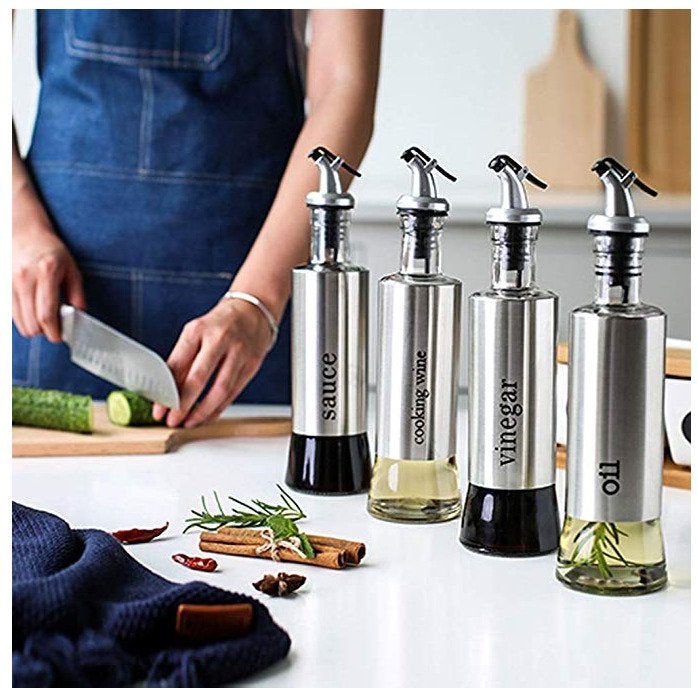 Showcasing the four filled bottles on a countertop while preparing food, highlighting their use beside recipe gathering materials.