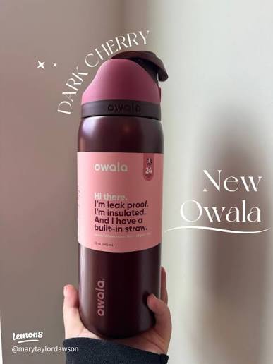 A hand holding an Owala insulated water bottle in a dark cherry color, with text overlays reading 'DARK CHERRY' and 'New Owala' on a neutral background.