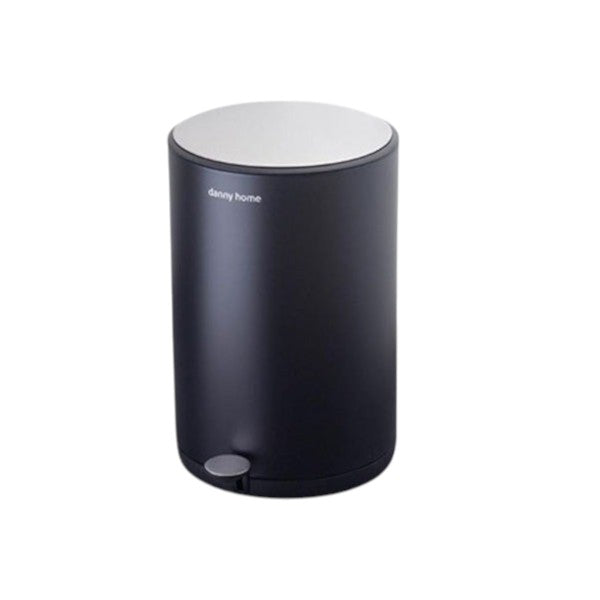 Black trash can with white top on a wooden surface