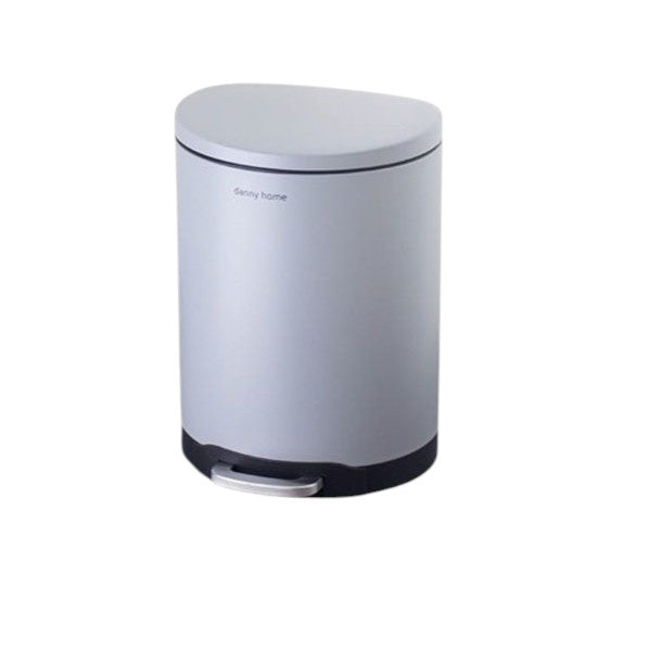 Silver trash can on a wooden floor with a white textured wall background