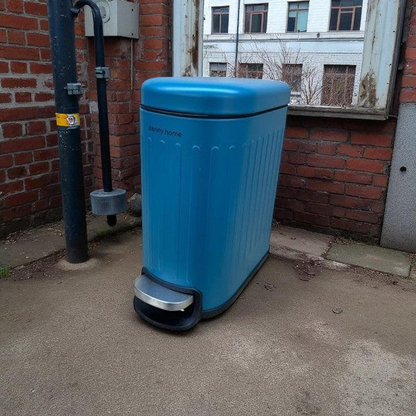 Blue trash bin against a brick wall